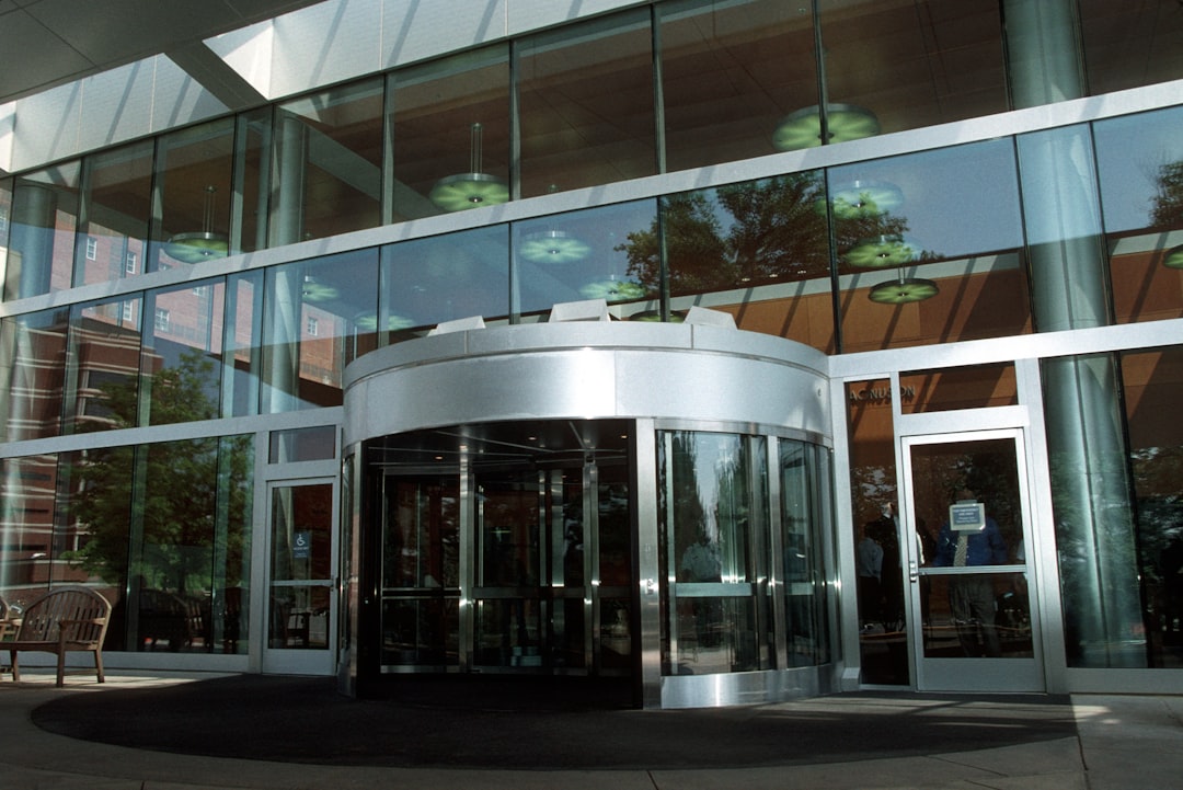Revolving door at a glass office building entrance, illustrating customers cycling in and out as churn
